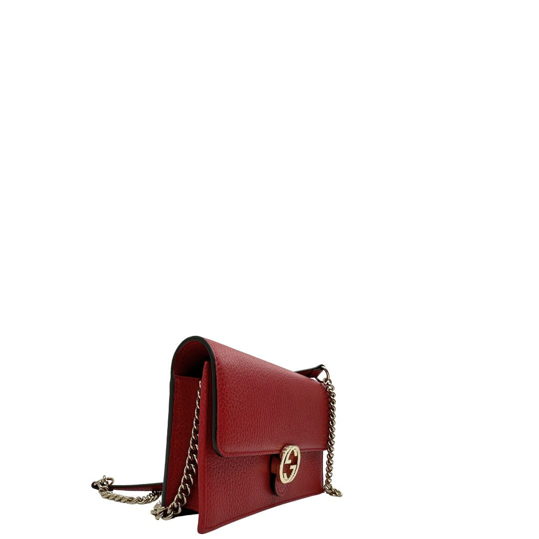 Laterale, Elegante borsa Gucci realizzata in pelle martellata rossa, caratterizzata dall’iconico logo Interlocking dorato. Indossabile a mano oppure a tracolla. Originale, usata, di lusso, in ottime condizioni.