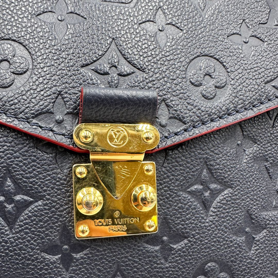 Chiusura, Borsa Louis Vuitton Métis in pelle monogram empreinte blu notte con parti metalliche dorate. Munita di un manico e tracolla regolabile con fibbia e amovibile. Originale, usata, di lusso, in ottime condizioni.