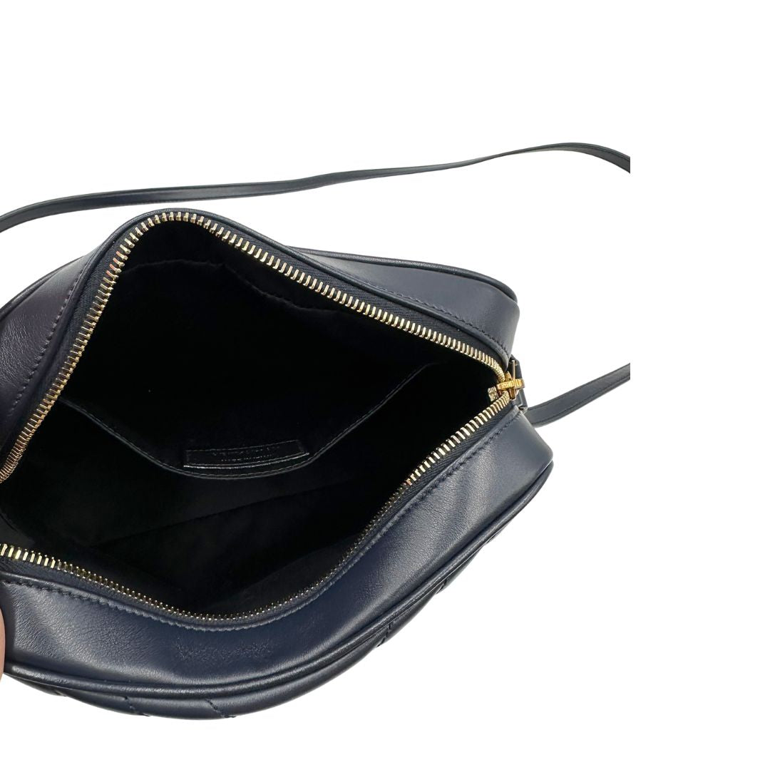 Interno di una borsa Saint Laurent blu navy con iconico logo centrale YSL, caratterizzata da impunture trapuntate ad “y” e nappa decorativa, usata, originale, second hand, in ottime condizioni.