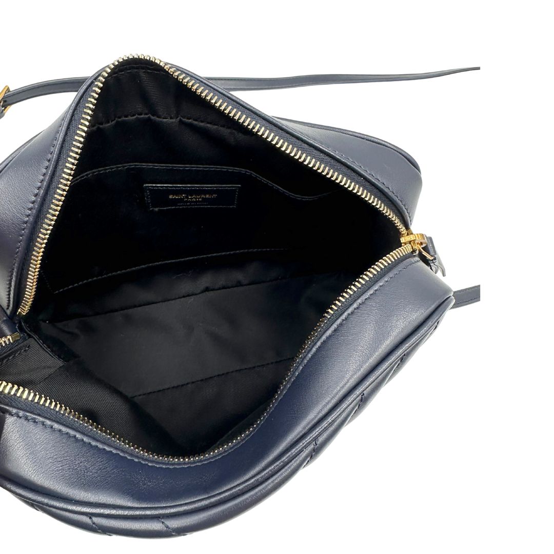 Interno di una borsa Saint Laurent blu navy con iconico logo centrale YSL, caratterizzata da impunture trapuntate ad “y” e nappa decorativa, usata, originale, second hand, in ottime condizioni.