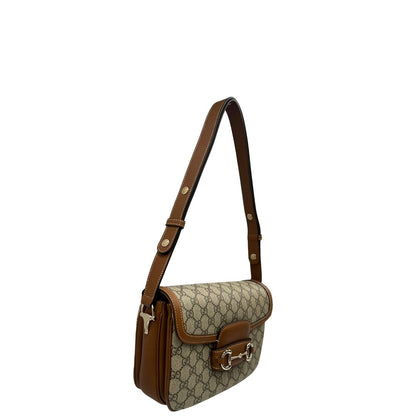 Laterale, Borsa Gucci in canvas beige GG e finiture in pelle color marrone con dettaglio Horsebit sulla chiusura. Borsa a spalla media con pattina frontale. Originale usata, di lusso, in ottime condizioni.