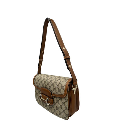 Laterale, Borsa Gucci in canvas beige GG e finiture in pelle color marrone con dettaglio Horsebit sulla chiusura. Borsa a spalla media con pattina frontale. Originale usata, di lusso, in ottime condizioni.
