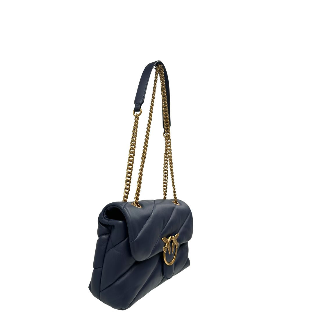 Laterale, Borsa Pinko nella versione media in morbida nappa blu trapuntata e hardware dorato, indossabile a tracolla o a spalla. Originale, usata, di lusso, in ottime condizioni.