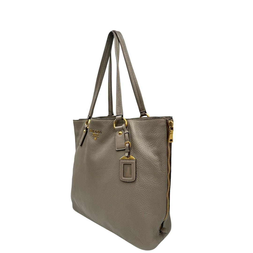 lato Borsa Prada in pelle grigia, dotata di doppi manici, dettagli in metallo dorato, di lusso, originale, ottime condizioni, usata 