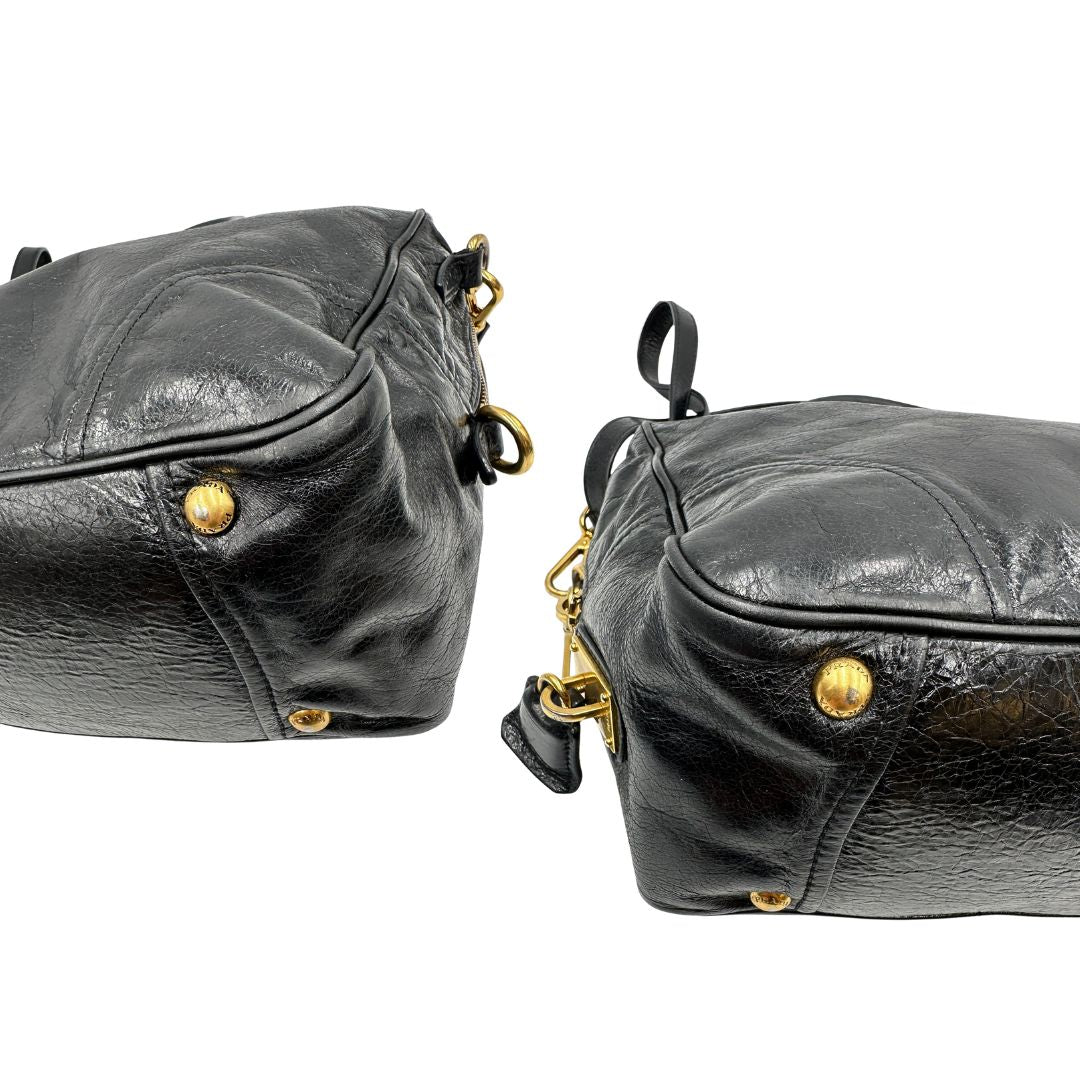 Borsa Prada in pelle nera effetto invecchiato, dotata di doppi manici e tracolla regolabile e amovibile con dettagli in metallo dorato, design capiente e versatile. Originale, usato, di lusso, in ottime condizioni.