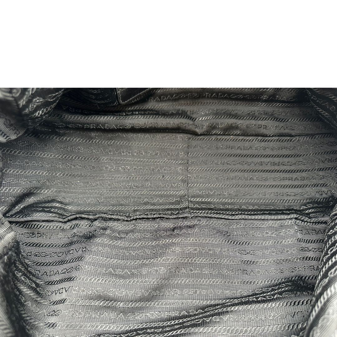 Borsa Prada in pelle nera effetto invecchiato, dotata di doppi manici e tracolla regolabile e amovibile con dettagli in metallo dorato, design capiente e versatile. Originale, usato, di lusso, in ottime condizioni.