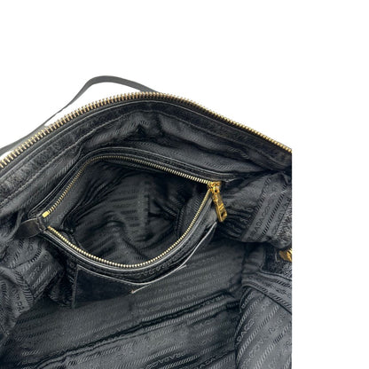 Borsa Prada in pelle nera effetto invecchiato, dotata di doppi manici e tracolla regolabile e amovibile con dettagli in metallo dorato, design capiente e versatile. Originale, usato, di lusso, in ottime condizioni.