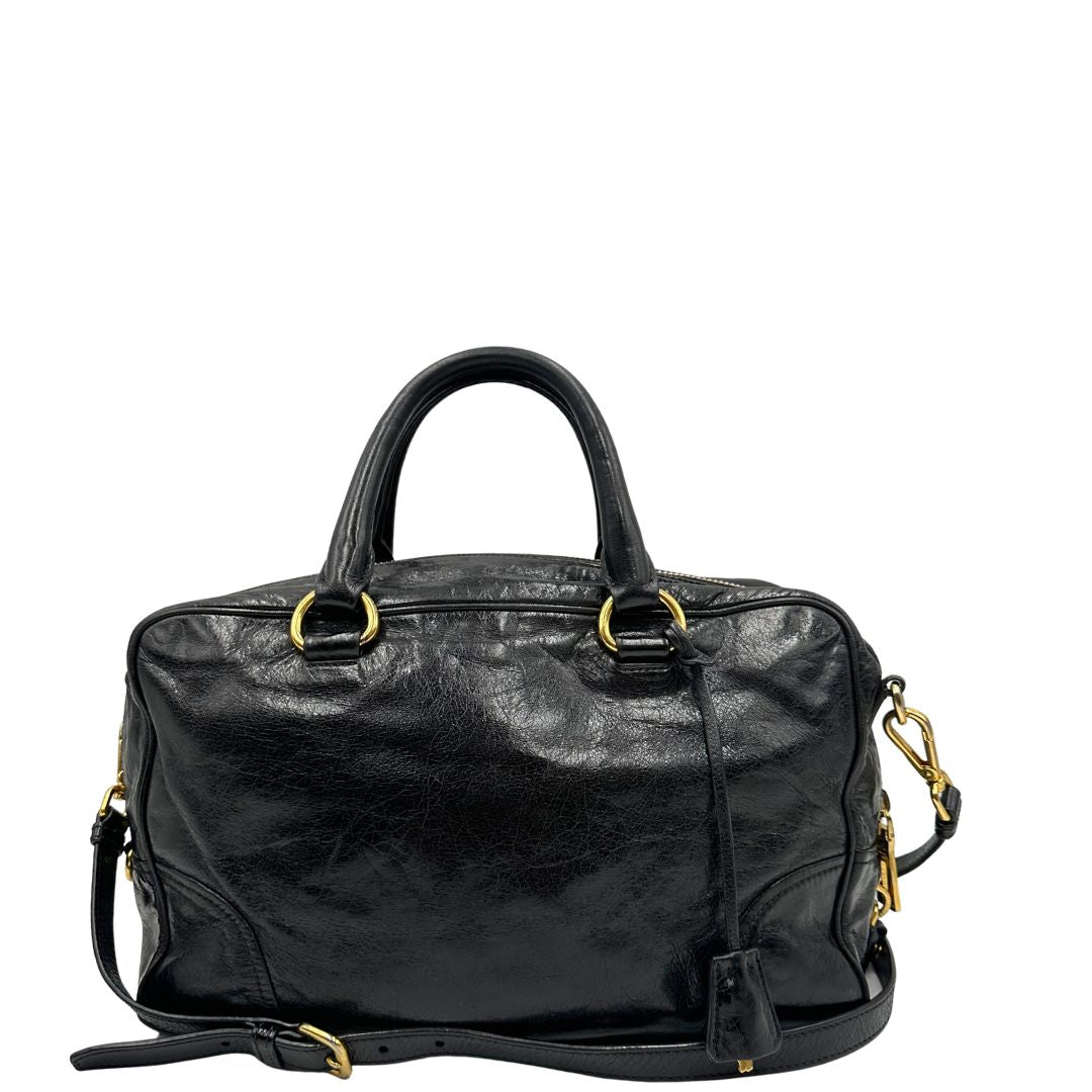 Borsa Prada in pelle nera effetto invecchiato, dotata di doppi manici e tracolla regolabile e amovibile con dettagli in metallo dorato, design capiente e versatile. Originale, usato, di lusso, in ottime condizioni.