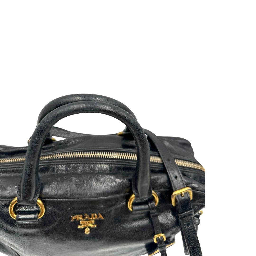 Borsa Prada in pelle nera effetto invecchiato, dotata di doppi manici e tracolla regolabile e amovibile con dettagli in metallo dorato, design capiente e versatile. Originale, usato, di lusso, in ottime condizioni.