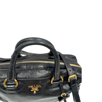 Borsa Prada in pelle nera effetto invecchiato, dotata di doppi manici e tracolla regolabile e amovibile con dettagli in metallo dorato, design capiente e versatile. Originale, usato, di lusso, in ottime condizioni.