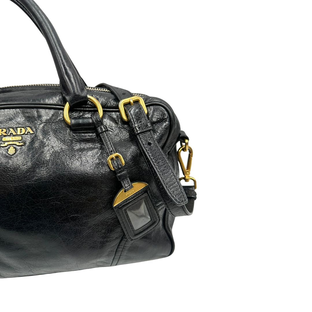 Borsa Prada in pelle nera effetto invecchiato, dotata di doppi manici e tracolla regolabile e amovibile con dettagli in metallo dorato, design capiente e versatile. Originale, usato, di lusso, in ottime condizioni.
