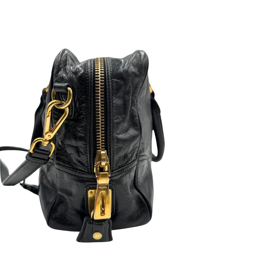 Borsa Prada in pelle nera effetto invecchiato, dotata di doppi manici e tracolla regolabile e amovibile con dettagli in metallo dorato, design capiente e versatile. Originale, usato, di lusso, in ottime condizioni.