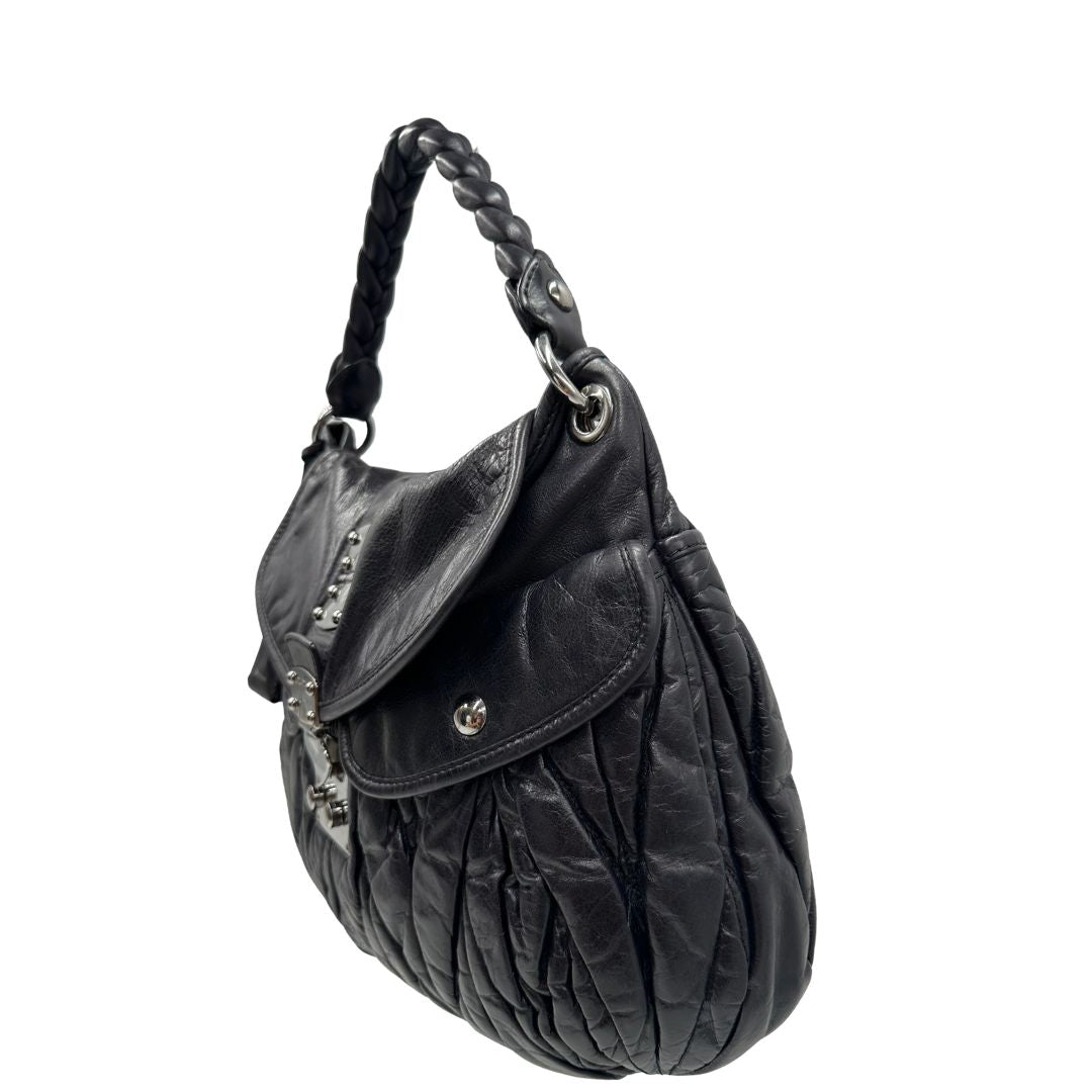 lato della borsa Miu Miu realizzata in pelle color viola melanzana con lavorazione matelassé, caratterizzata da morbide arricciature, di lusso, originale, ottime condizioni, usata 