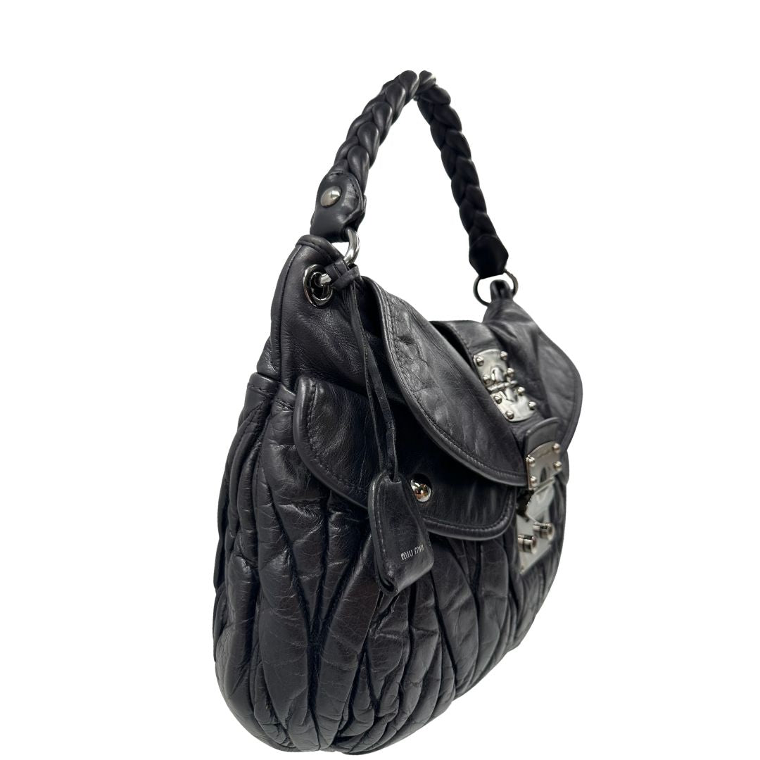 lato della borsa Miu Miu realizzata in pelle color viola melanzana con lavorazione matelassé, caratterizzata da morbide arricciature, di lusso, originale, ottime condizioni, usata