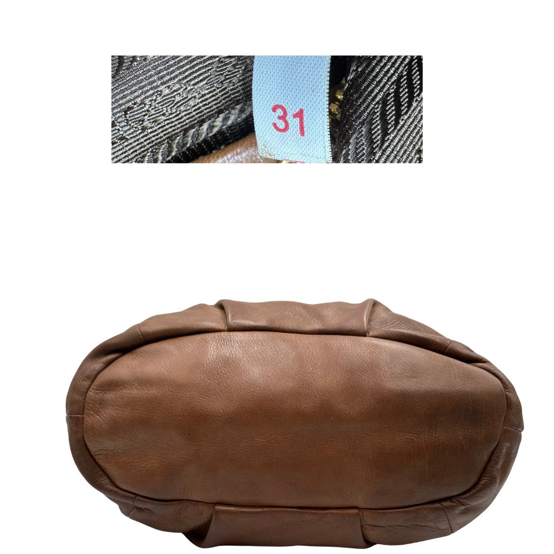 Codice e base, Capiente borsa Prada in pelle marrone con hardware dorato, munita di doppi manici stondati e una tracolla regolabile ed amovibile. Originale, usata, di lusso, in ottime condizioni.