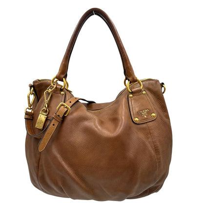 Front, Capiente borsa Prada in pelle marrone con hardware dorato, munita di doppi manici stondati e una tracolla regolabile ed amovibile. Originale, usata, di lusso, in ottime condizioni.