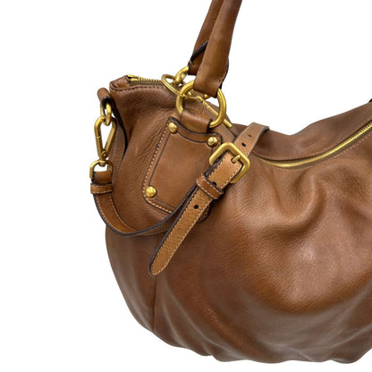 Capiente borsa Prada in pelle marrone con hardware dorato, munita di doppi manici stondati e una tracolla regolabile ed amovibile. Originale, usata, di lusso, in ottime condizioni.