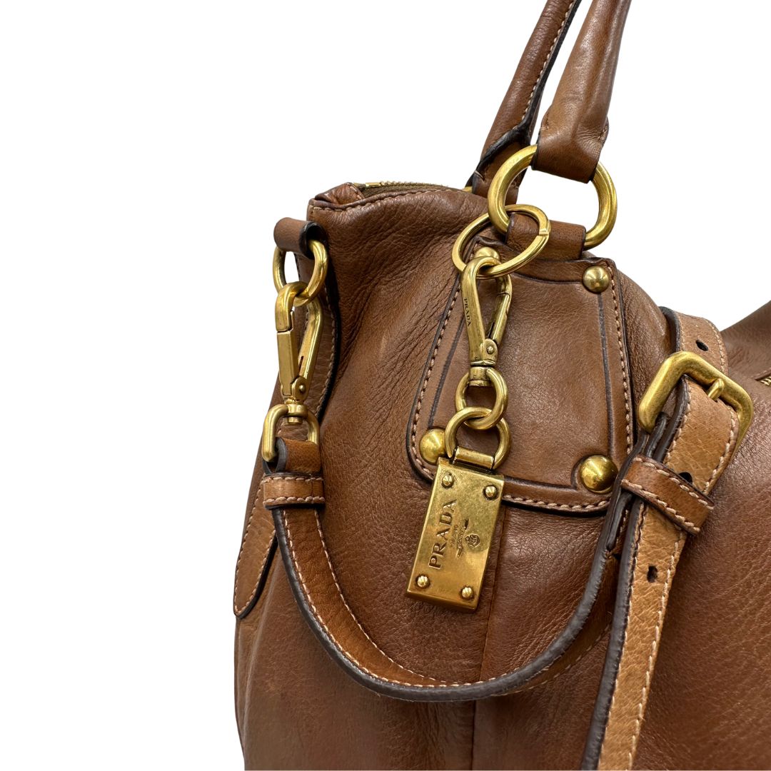Capiente borsa Prada in pelle marrone con hardware dorato, munita di doppi manici stondati e una tracolla regolabile ed amovibile. Originale, usata, di lusso, in ottime condizioni.