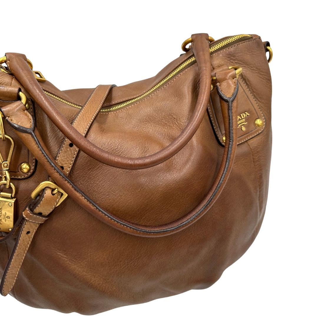 Manici, Capiente borsa Prada in pelle marrone con hardware dorato, munita di doppi manici stondati e una tracolla regolabile ed amovibile. Originale, usata, di lusso, in ottime condizioni.