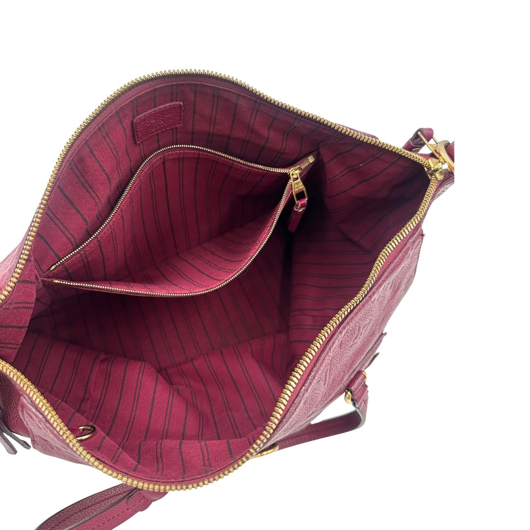 Interno, Louis Vuitton in pelle monogram empreinte color magenta con hardware dorato , munita di doppi manici. Indossabile a spalla. Originale, usata, di lusso, in ottime condizioni.