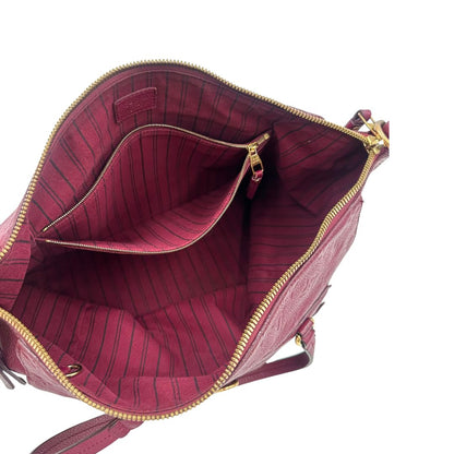 Interno, Louis Vuitton in pelle monogram empreinte color magenta con hardware dorato , munita di doppi manici. Indossabile a spalla. Originale, usata, di lusso, in ottime condizioni.