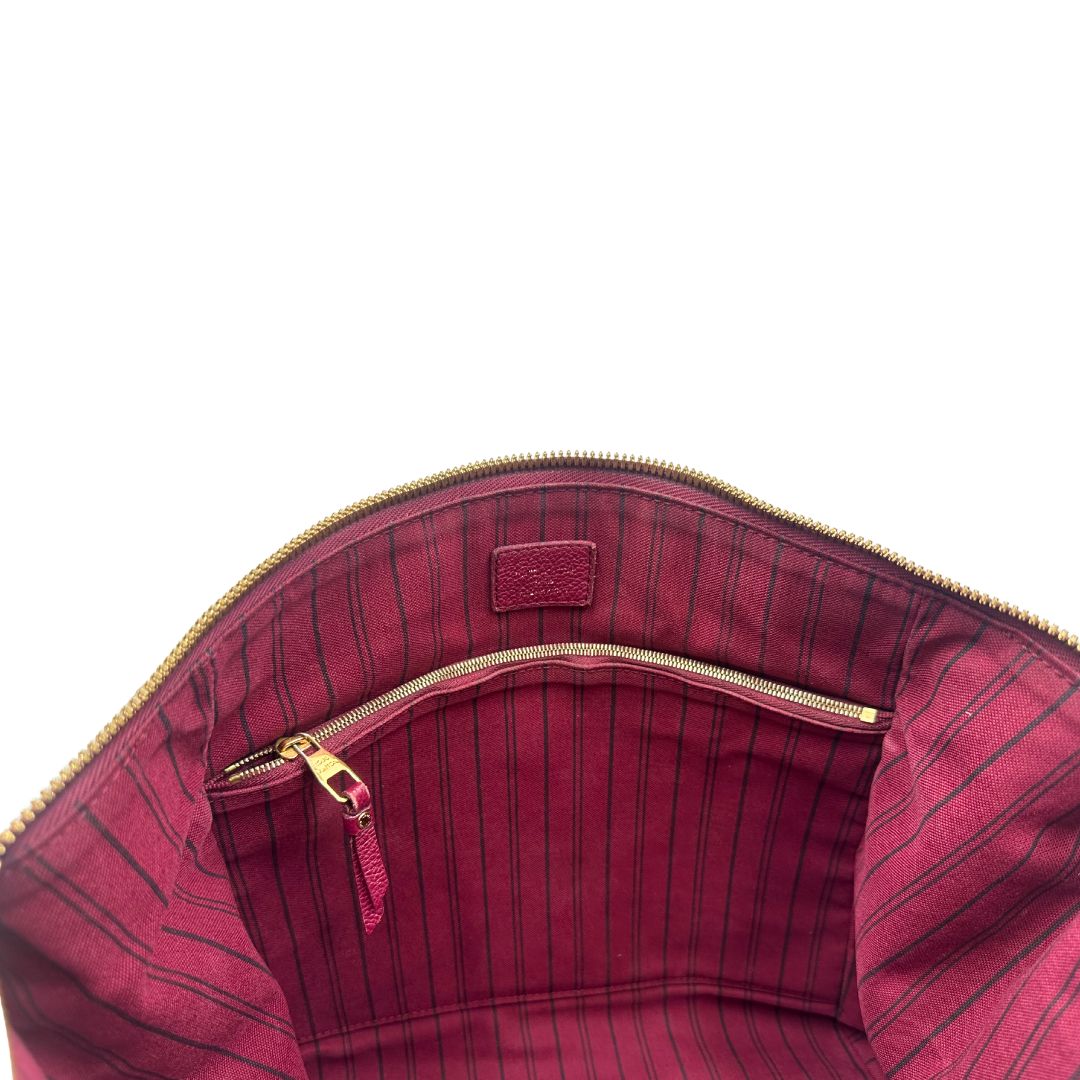 Tasca interna, Louis Vuitton in pelle monogram empreinte color magenta con hardware dorato , munita di doppi manici. Indossabile a spalla. Originale, usata, di lusso, in ottime condizioni.