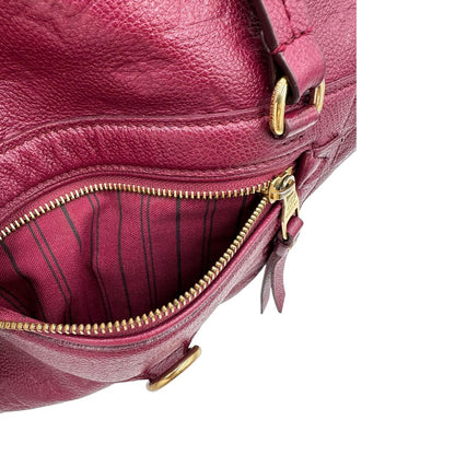 Tasca esterna, Louis Vuitton in pelle monogram empreinte color magenta con hardware dorato , munita di doppi manici. Indossabile a spalla. Originale, usata, di lusso, in ottime condizioni.