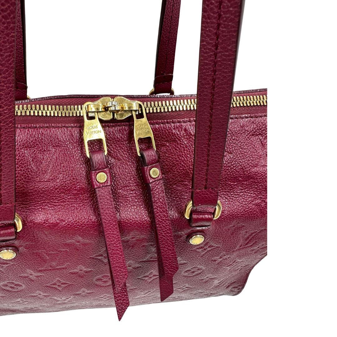 Chiusura, Louis Vuitton in pelle monogram empreinte color magenta con hardware dorato , munita di doppi manici. Indossabile a spalla. Originale, usata, di lusso, in ottime condizioni.