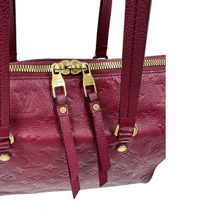 Chiusura, Louis Vuitton in pelle monogram empreinte color magenta con hardware dorato , munita di doppi manici. Indossabile a spalla. Originale, usata, di lusso, in ottime condizioni.