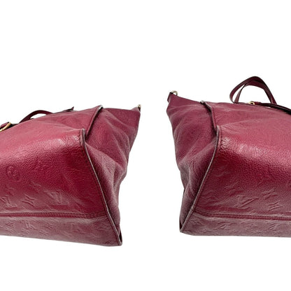 Angoli, Louis Vuitton in pelle monogram empreinte color magenta con hardware dorato , munita di doppi manici. Indossabile a spalla. Originale, usata, di lusso, in ottime condizioni.