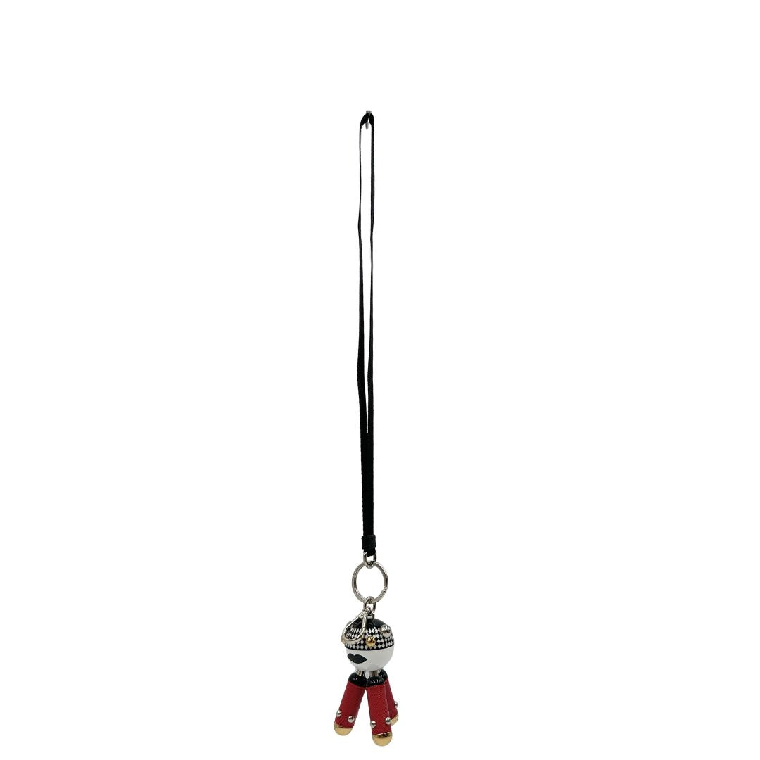 Charm Prada presenta una testa a sfera con un motivo a scacchi bianchi e neri e dettagli metallici color oro, le gambe sono realizzate in pelle saffiano rossa. Originale, usato, di lusso, in condizioni eccellenti.