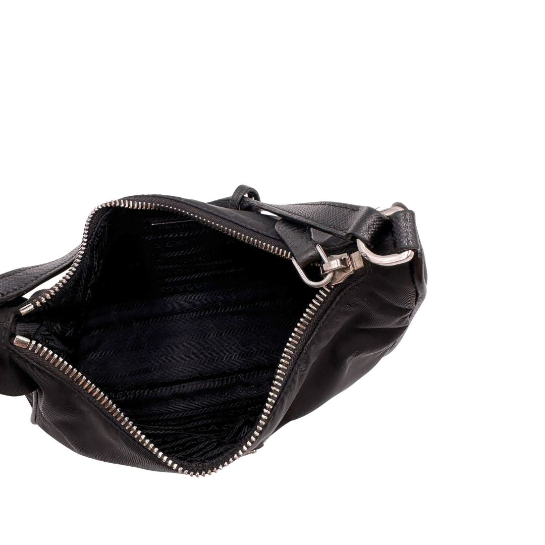 Interno, Borsa Prada in re-nylon nero con finiture in pelle saffiano tono su tono; indossabile a spalla. Originale, usata, di lusso, in ottime condizioni.