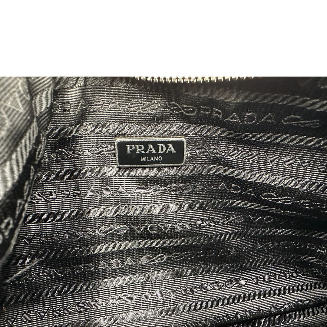 Interno, Borsa Prada in re-nylon nero con finiture in pelle saffiano tono su tono; indossabile a spalla. Originale, usata, di lusso, in ottime condizioni.