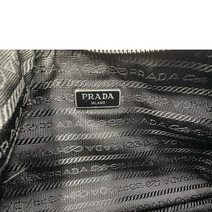 Interno, Borsa Prada in re-nylon nero con finiture in pelle saffiano tono su tono; indossabile a spalla. Originale, usata, di lusso, in ottime condizioni.