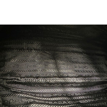 Interno, Borsa Prada in re-nylon nero con finiture in pelle saffiano tono su tono; indossabile a spalla. Originale, usata, di lusso, in ottime condizioni.