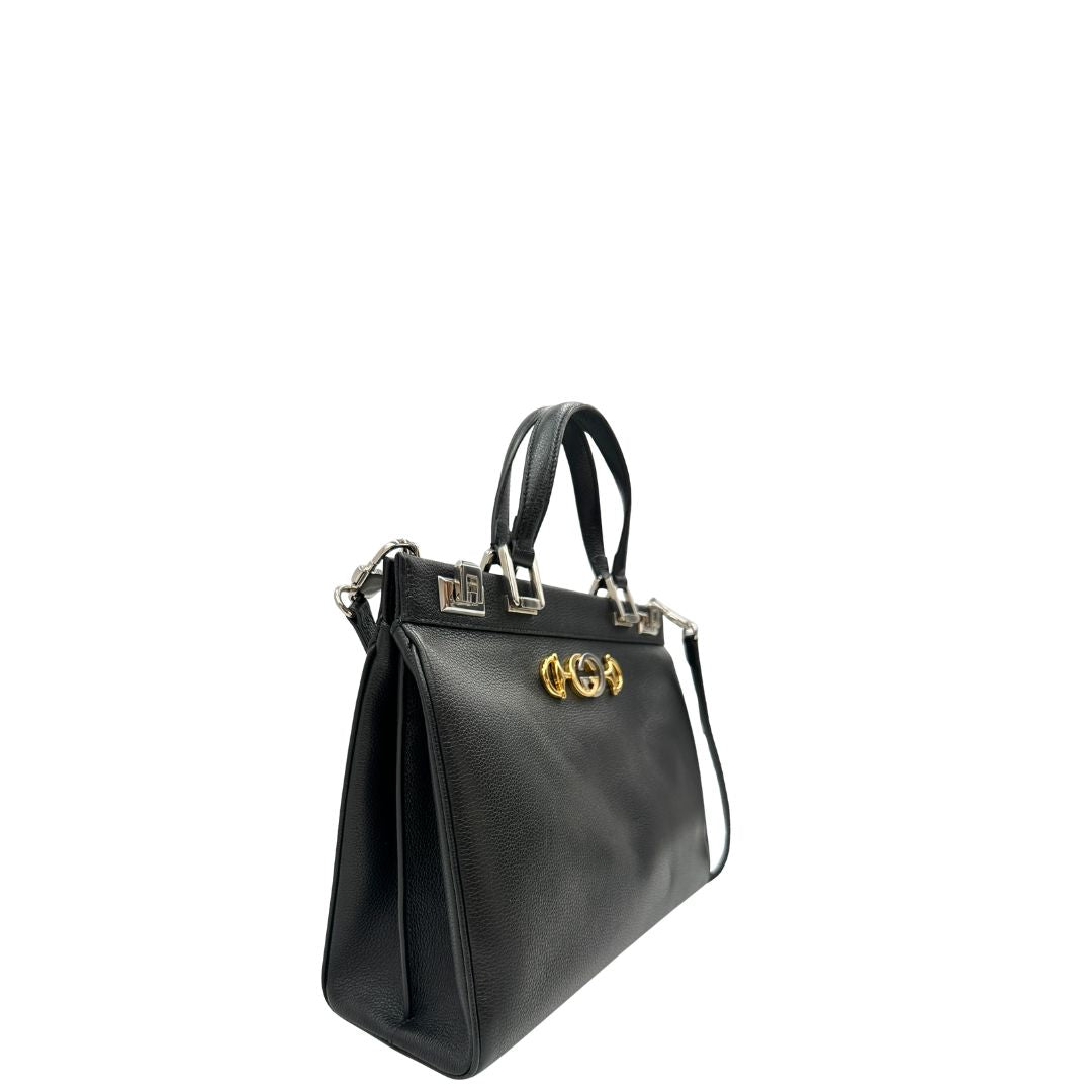 Lato, Borsa Gucci in pelle martellata nera caratterizzata dal dettaglio Horsebit in metallo dorato e argentato con doppie G sul front. Indossabile a mano oppure a spalla. Originale, usata, di lusso, in ottime condizioni.