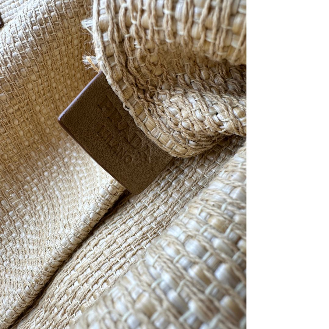 Elegante borsa tote Prada in rafia beige con manici sottili in pelle e il grande logo stampato sul davanti. Originale, usata, di lusso, in ottime condizioni.