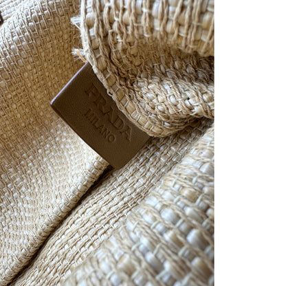 Elegante borsa tote Prada in rafia beige con manici sottili in pelle e il grande logo stampato sul davanti. Originale, usata, di lusso, in ottime condizioni.