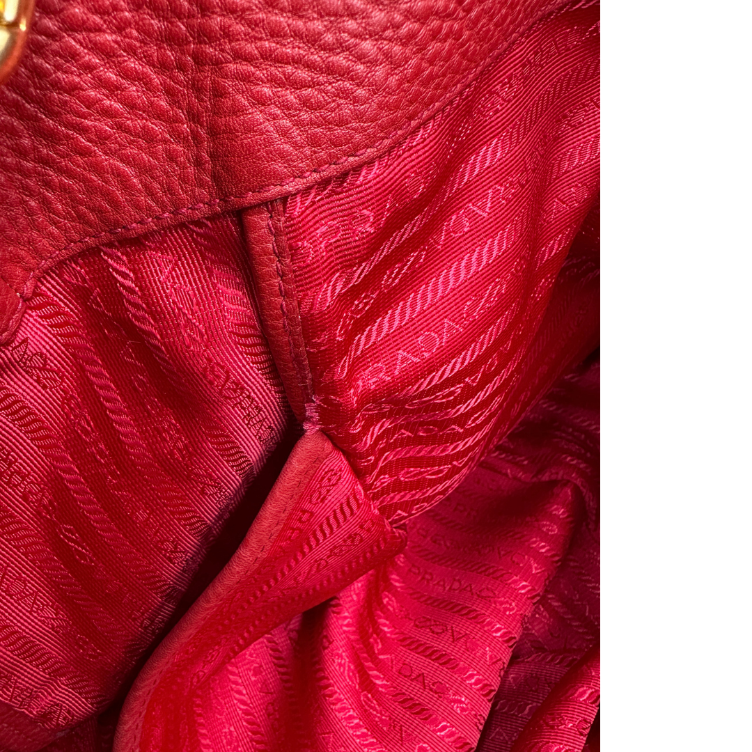 Borsa Prada in pelle martellata rossa, indossabile a mano e anche a tracolla. Originale, usata, di lusso, in ottime condizioni.