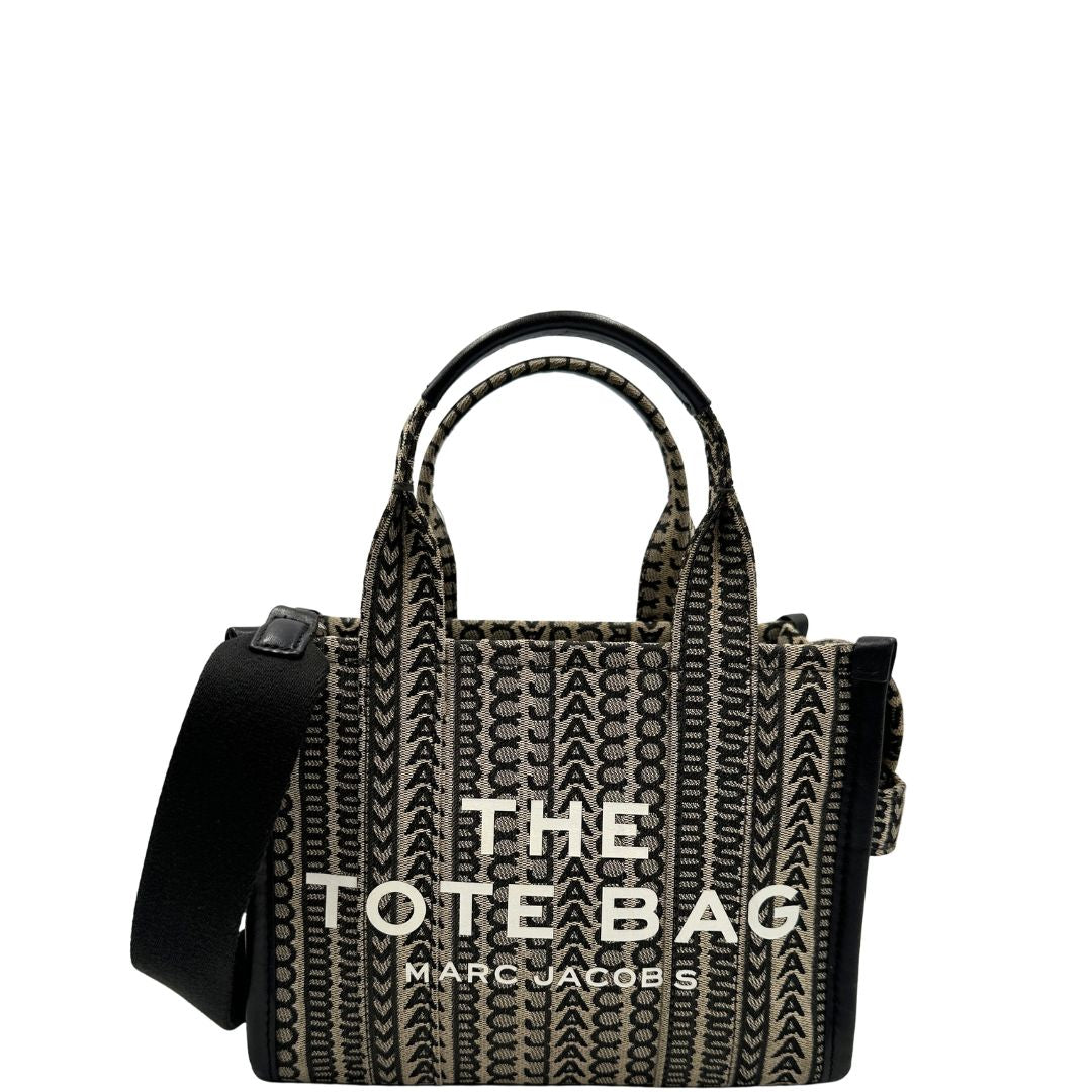 front  borsa Marc Jacobs The Monogram Mini Tote in tessuto jacquard con motivo geometrico a contrasto e la caratteristica scritta bianca "THE TOTE BAG".
