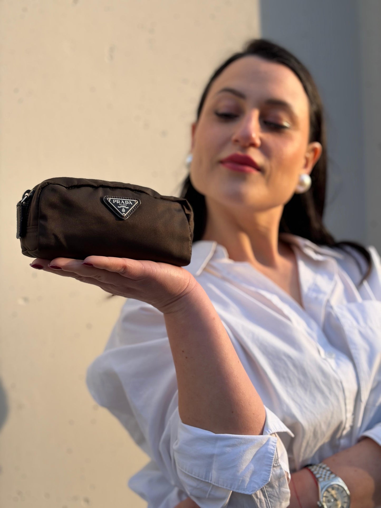 Ragazza che indossa un beauty Prada in tessuto Vela color ebano e hardware argentato, usato, originale, second hand, in ottime condizioni.