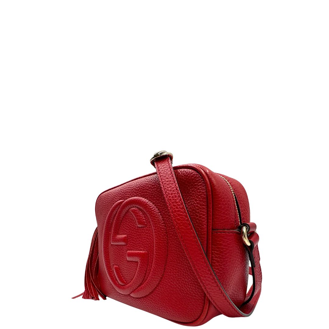 lato  Borsa Gucci in pelle martellata rossa con parti metalliche dorate; impreziosita da nappa e munita di una tracolla. Completa di dustbag, di lusso, originale, ottime condizioni, usata. 