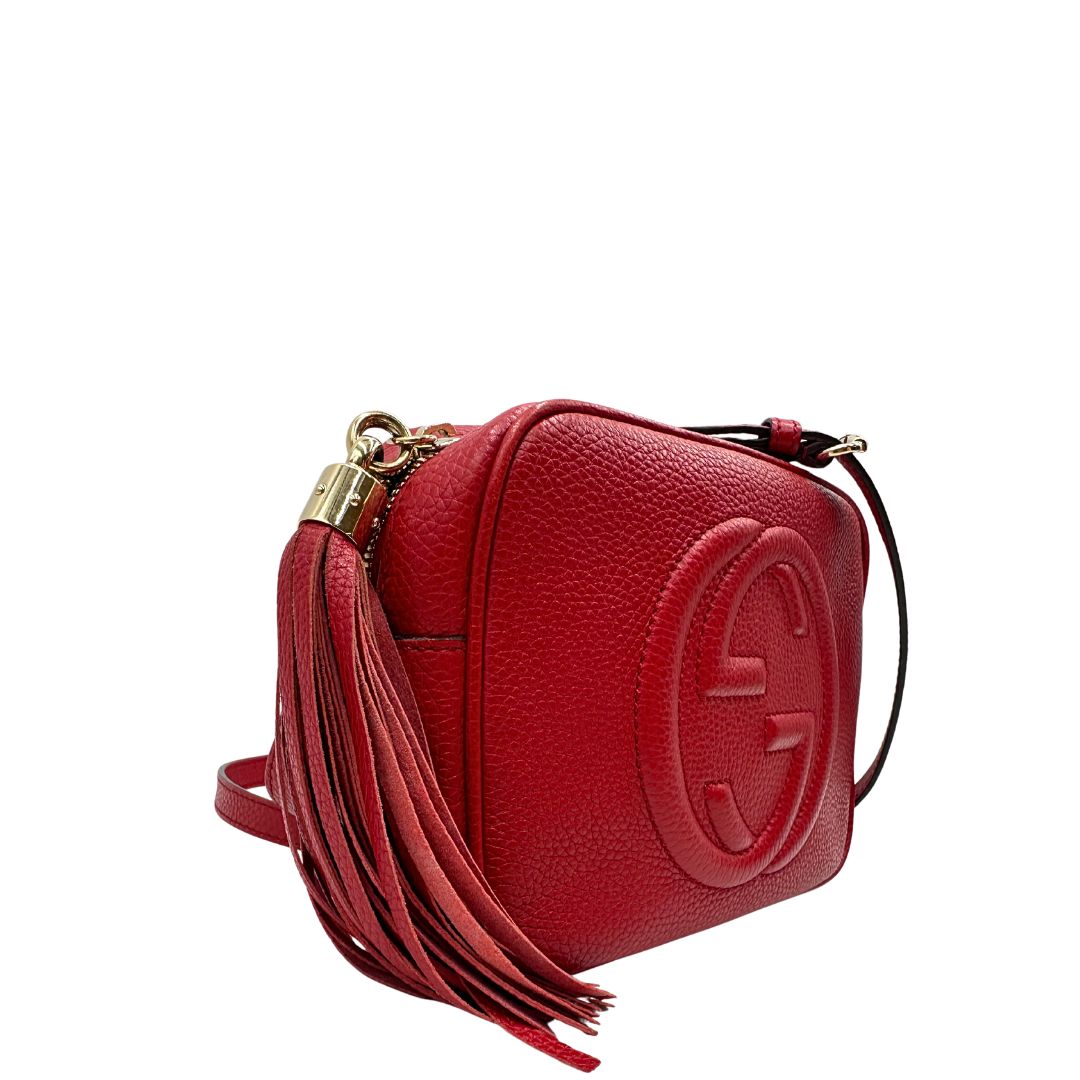 lato  Borsa Gucci in pelle martellata rossa con parti metalliche dorate; impreziosita da nappa e munita di una tracolla. Completa di dustbag, di lusso, originale, ottime condizioni, usata. 
