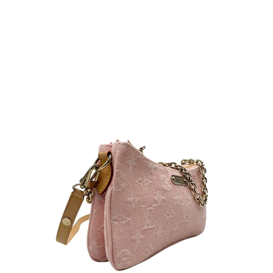Laterale sinistro di una pochette Liv in denim rosa baby trama monogram, versatile e sicura, con doppia zip, catenella dorata e tracolla regolabile amovibili, usata, originale, second hand, in condizioni eccellenti.