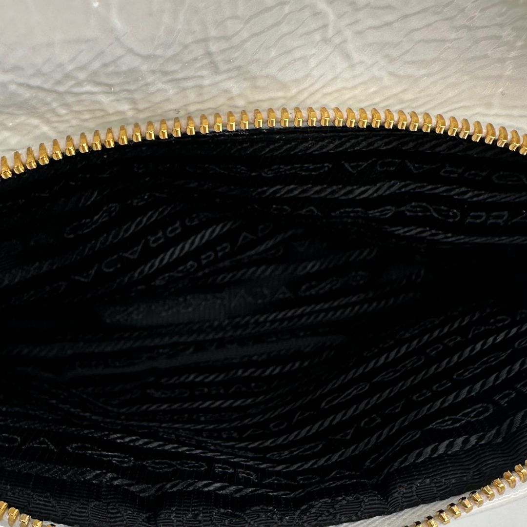 interno Secchiello Prada in pelle verniciata bianca con parti metalliche dorate; munito di un manico singolo e una tracolla amovibile e regolabile, di lusso, originale, ottime condizioni, usato. 