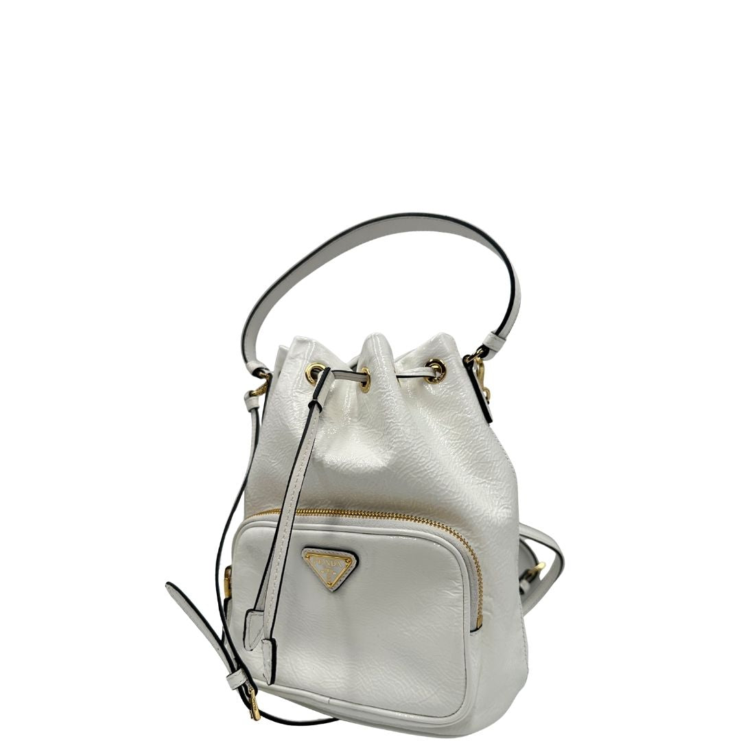 lato Secchiello Prada in pelle verniciata bianca con parti metalliche dorate; munito di un manico singolo e una tracolla amovibile e regolabile, di lusso, originale, ottime condizioni, usato. 