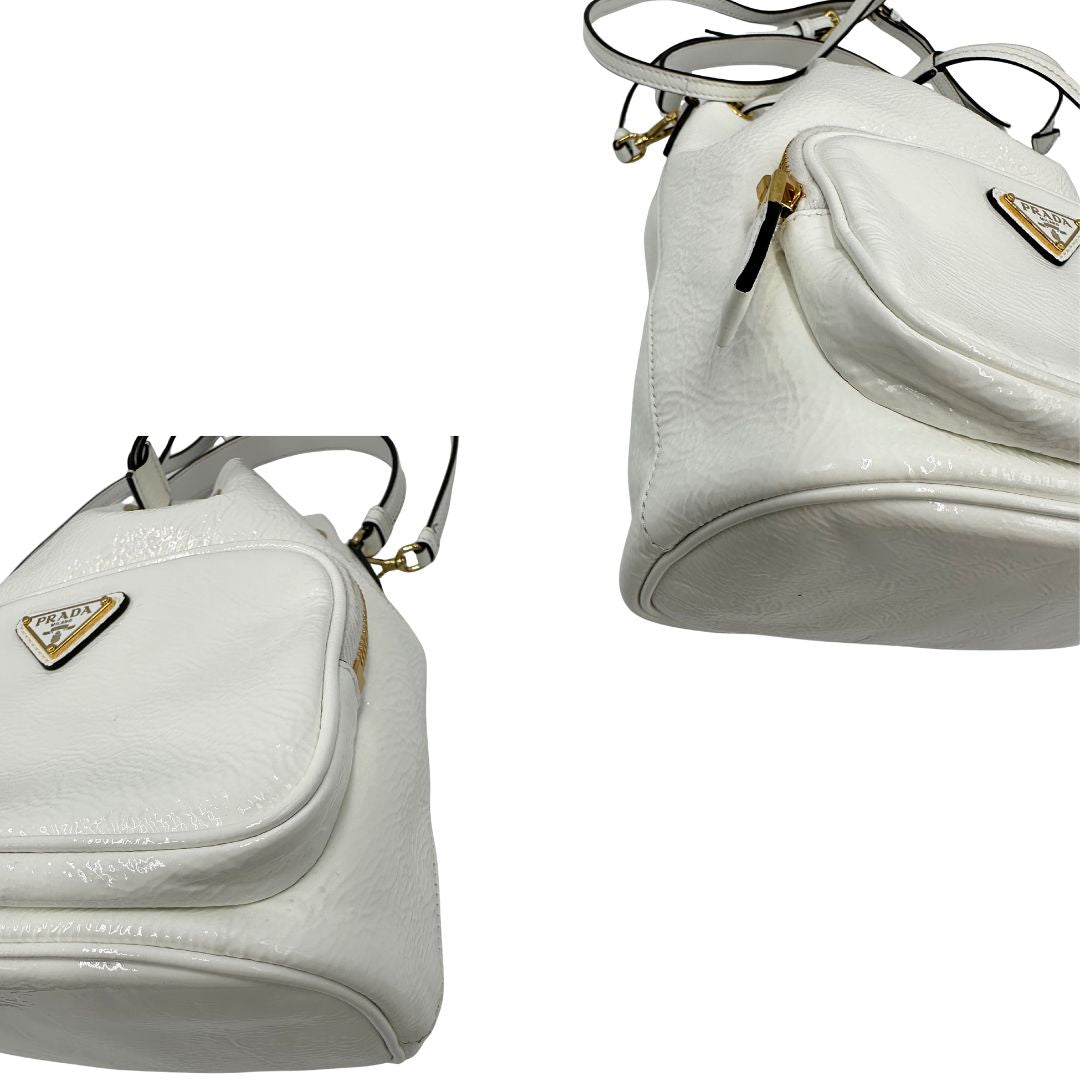 angoli Secchiello Prada in pelle verniciata bianca con parti metalliche dorate; munito di un manico singolo e una tracolla amovibile e regolabile, di lusso, originale, ottime condizioni, usato. 