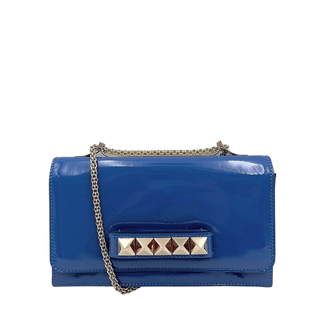 Foto pochette con tracolla Valentino Garavani in pelle vernis azzurra con borchie. Borse di lusso di marca usate.