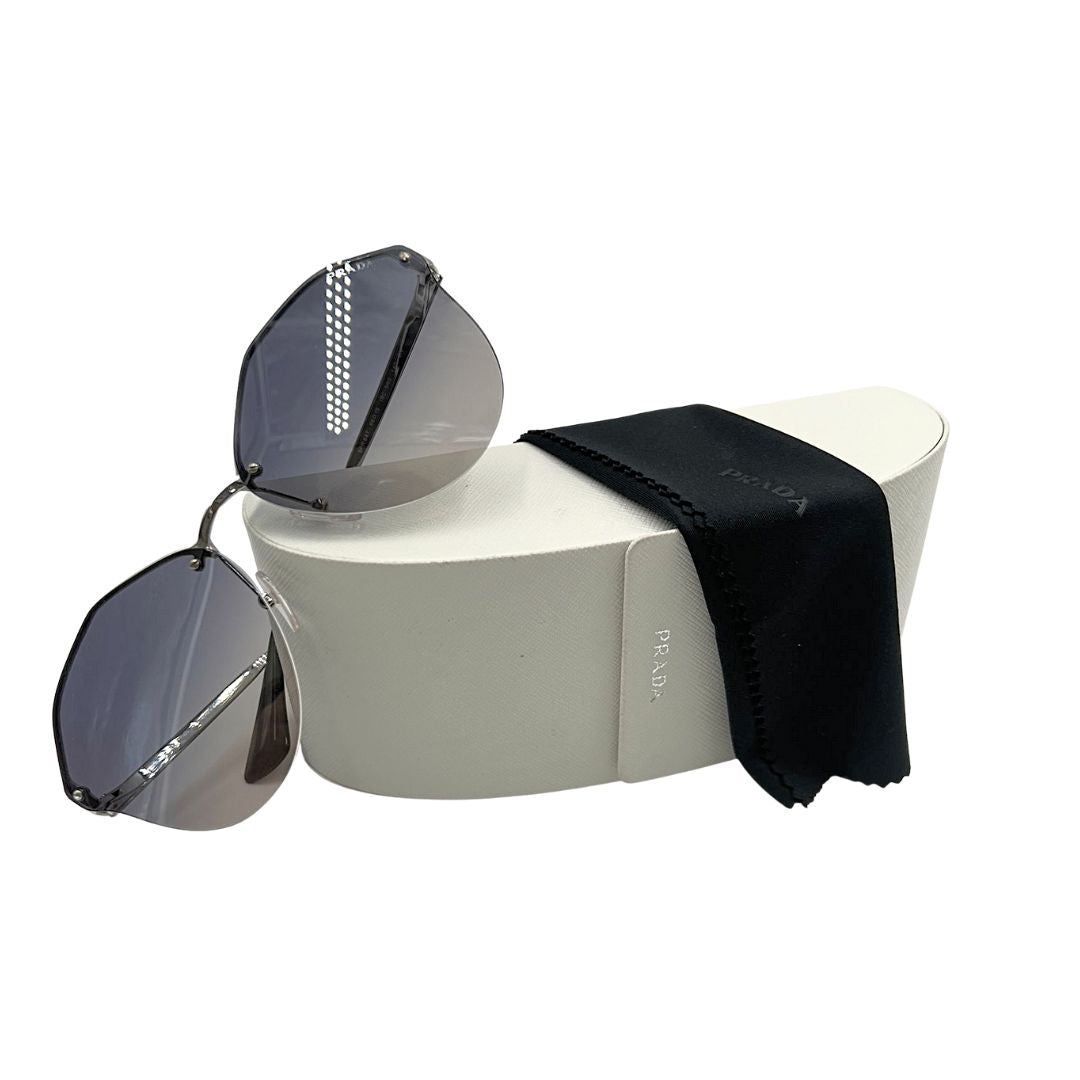 Foto occhiali da sole Prada con lenti trasparenti grigio. Accessori di lusso usati.